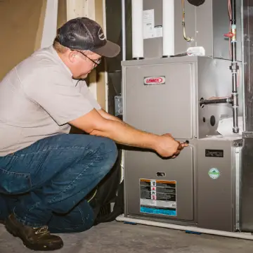 worker performing furnace maintenance